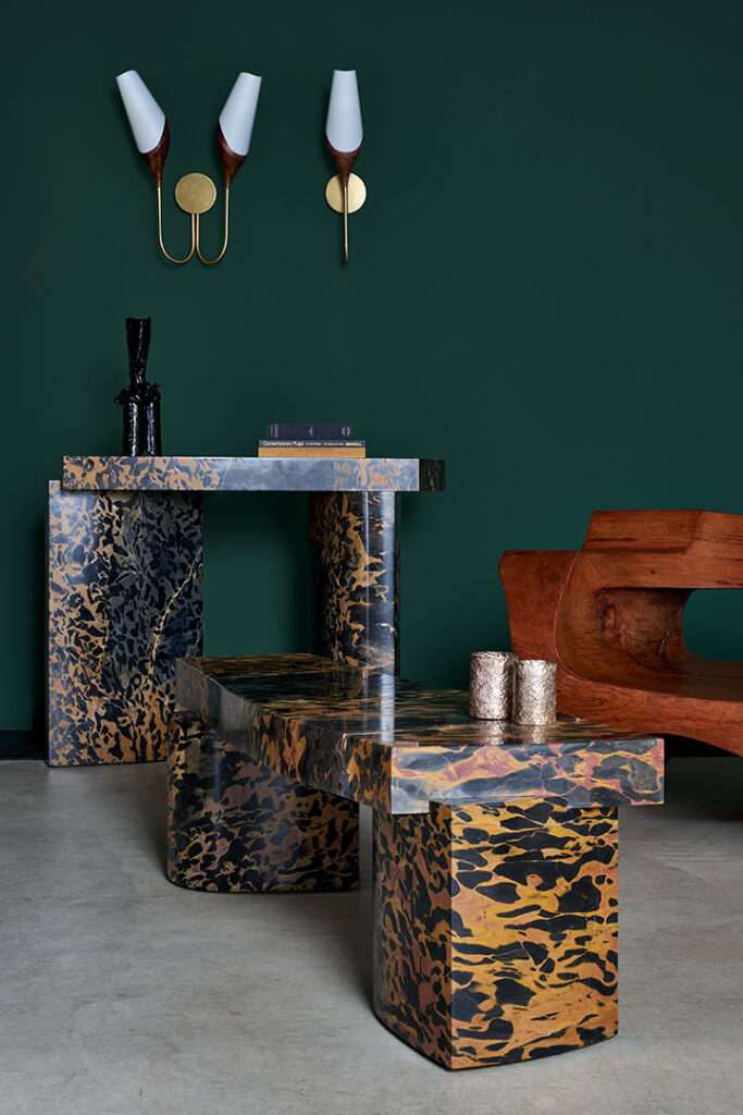 José Zanine Caldas wood sofa & Roberto Sironi marble console and low table, on a green backdrop with two Joe Armitage appliques